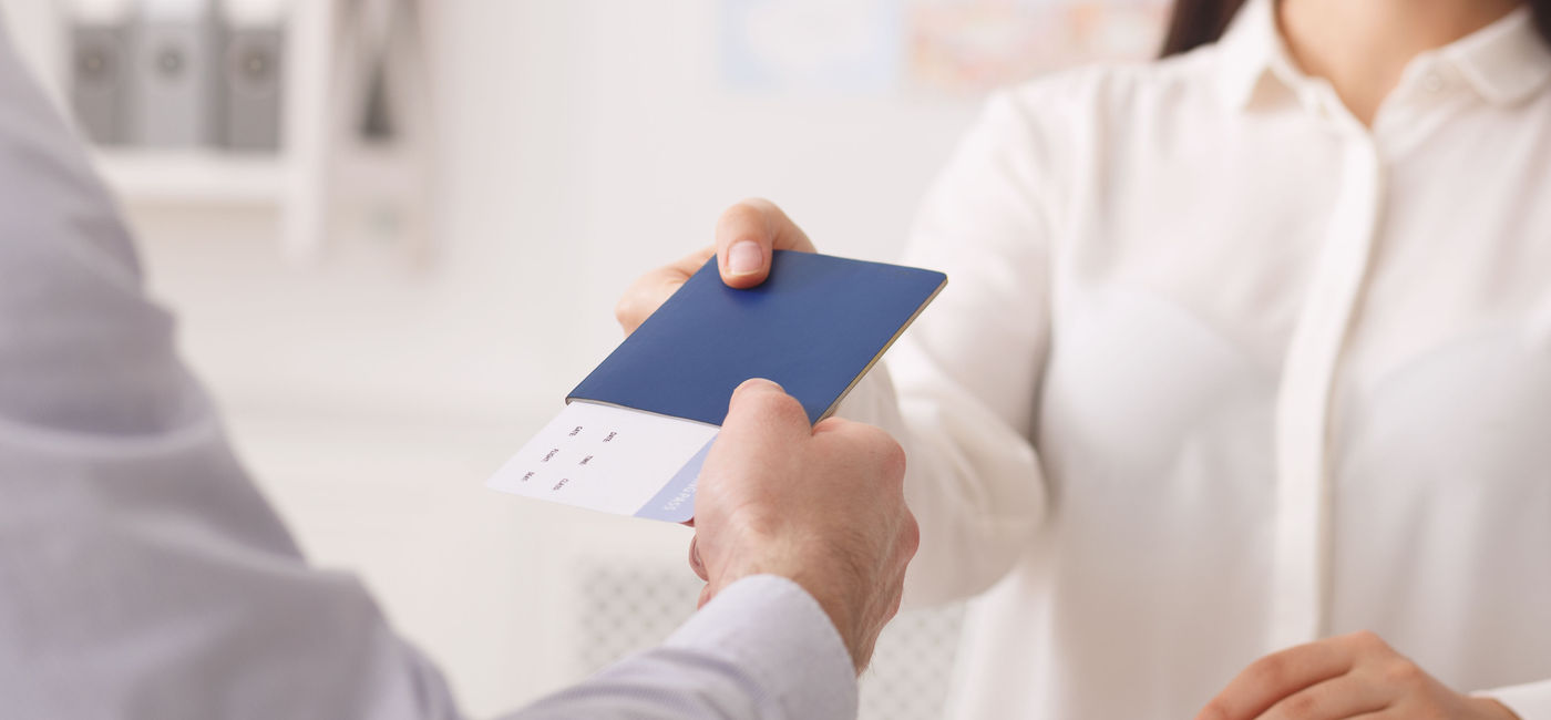 Image: Travel advisor hands over travel itinerary to client (photo via Prostock-Studio / Getty Images) (Prostock-Studio / Getty Images))