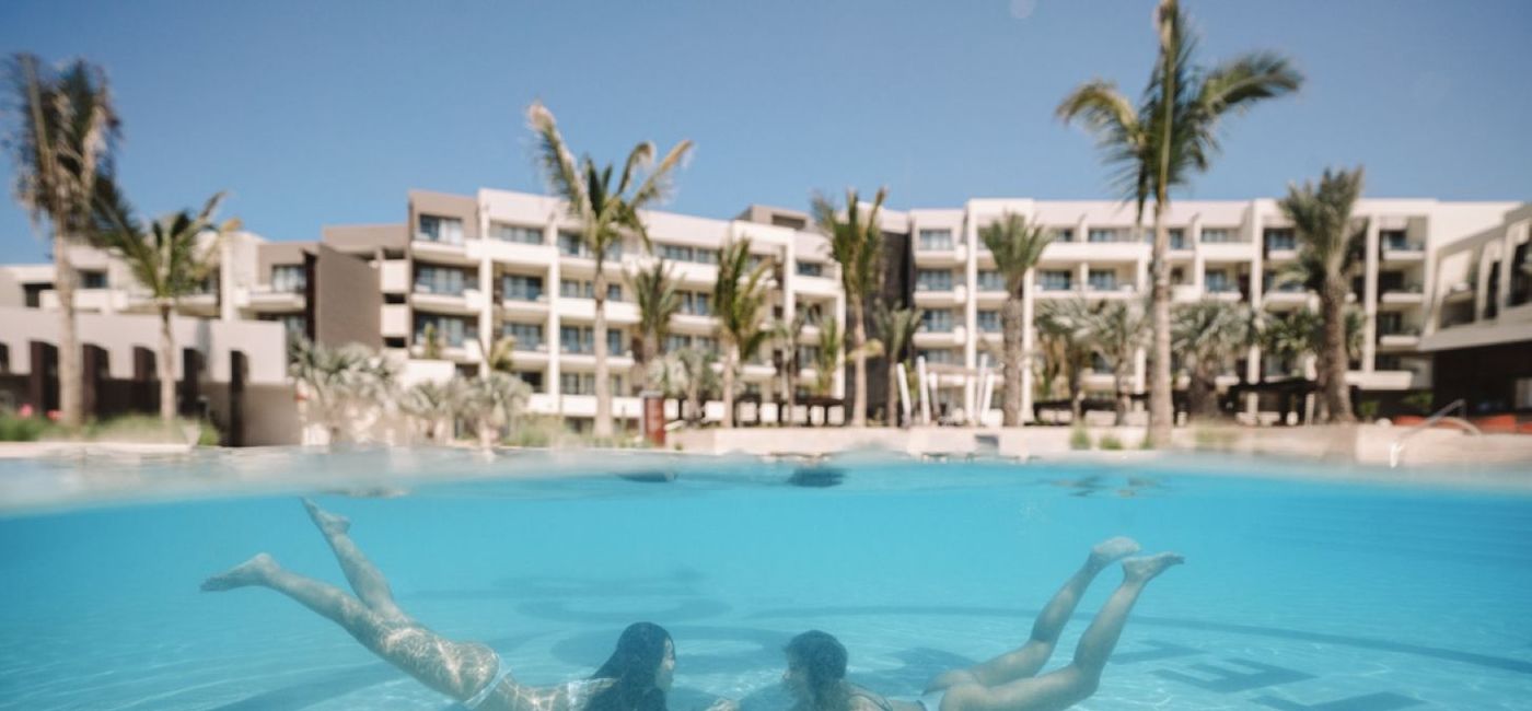 Image: Two women swim in a pool. (photo via Hard Rock Hotels). ((photo via Hard Rock Hotels))