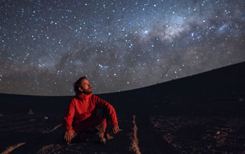 Man observing the Milky Way galaxy in the Atacama Desert, Chile.