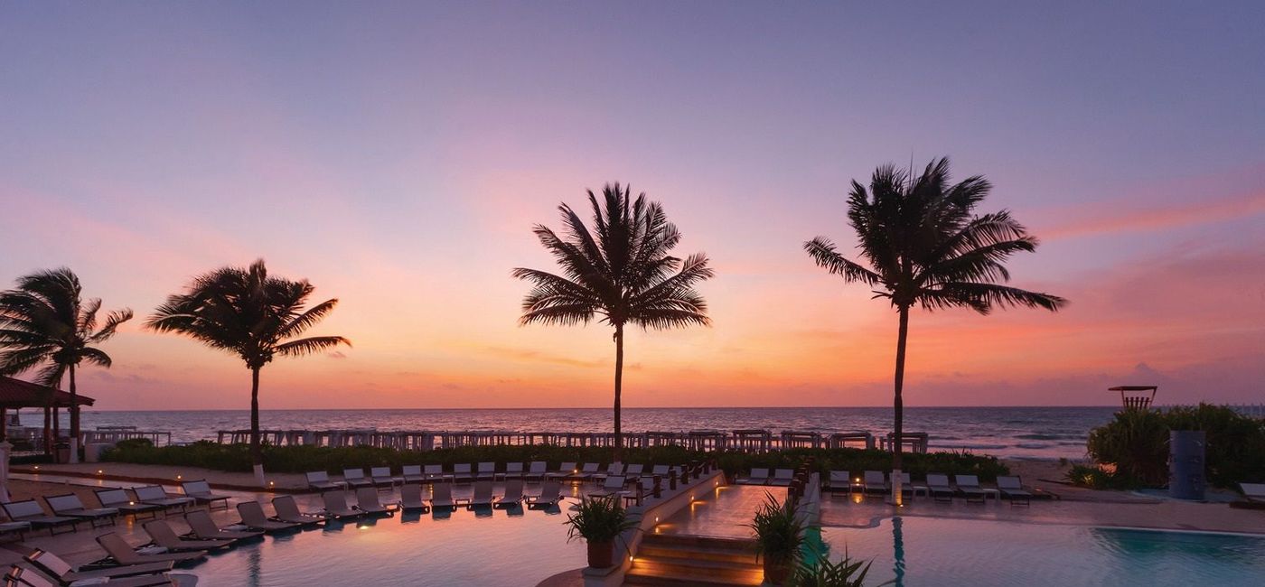 Image: A colorful sky over a pool at Hilton Playa del Carmen. (photo via Playa Hotels & Resorts)