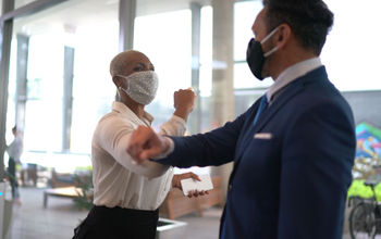 Business people safely greet each other.
