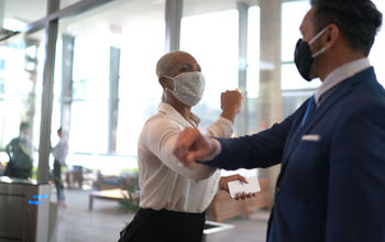 Business people safely greet each other.