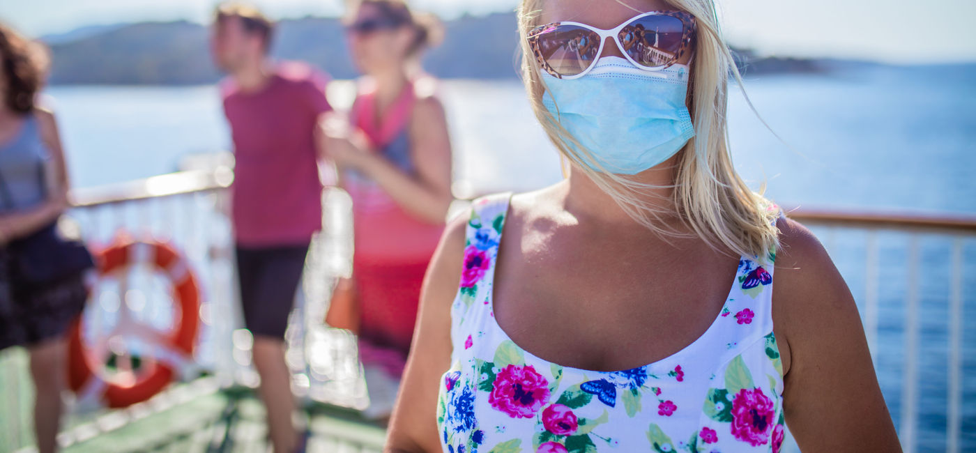 Image: A masked cruise ship passenger. (photo courtesy SimonSkafar/iStock/Getty Images Plus)