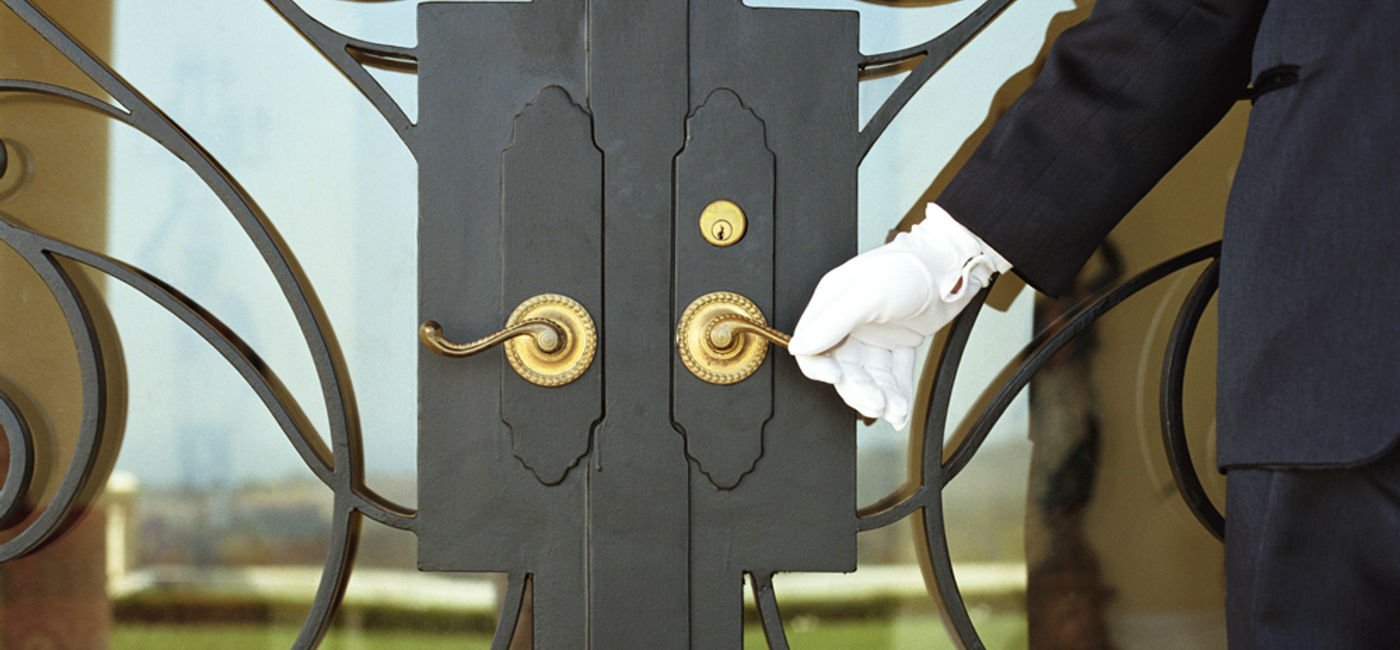 Image: PHOTO: A white-gloved butler opens a door. (photo courtesy of Thinkstock)