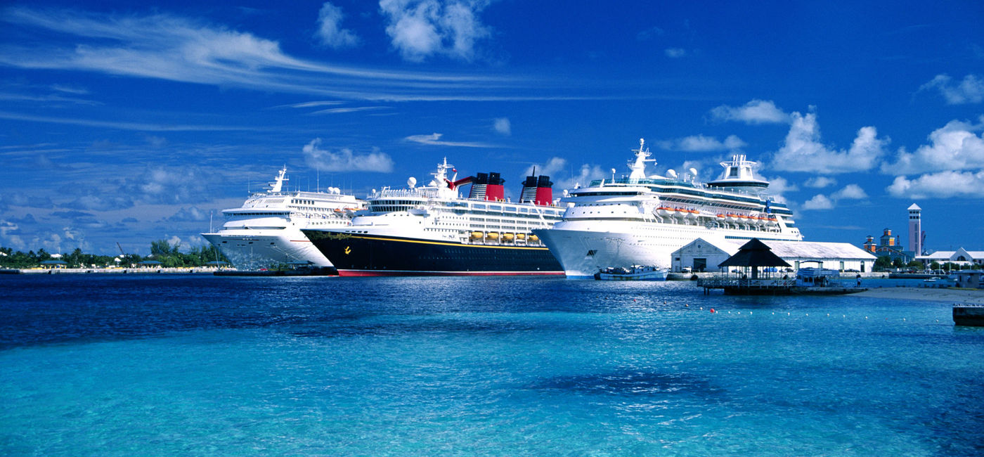 Image: Cruise ships at a port in The Bahamas. (photo via Brand X Pictures / Stockbyte / Getty Images Plus)