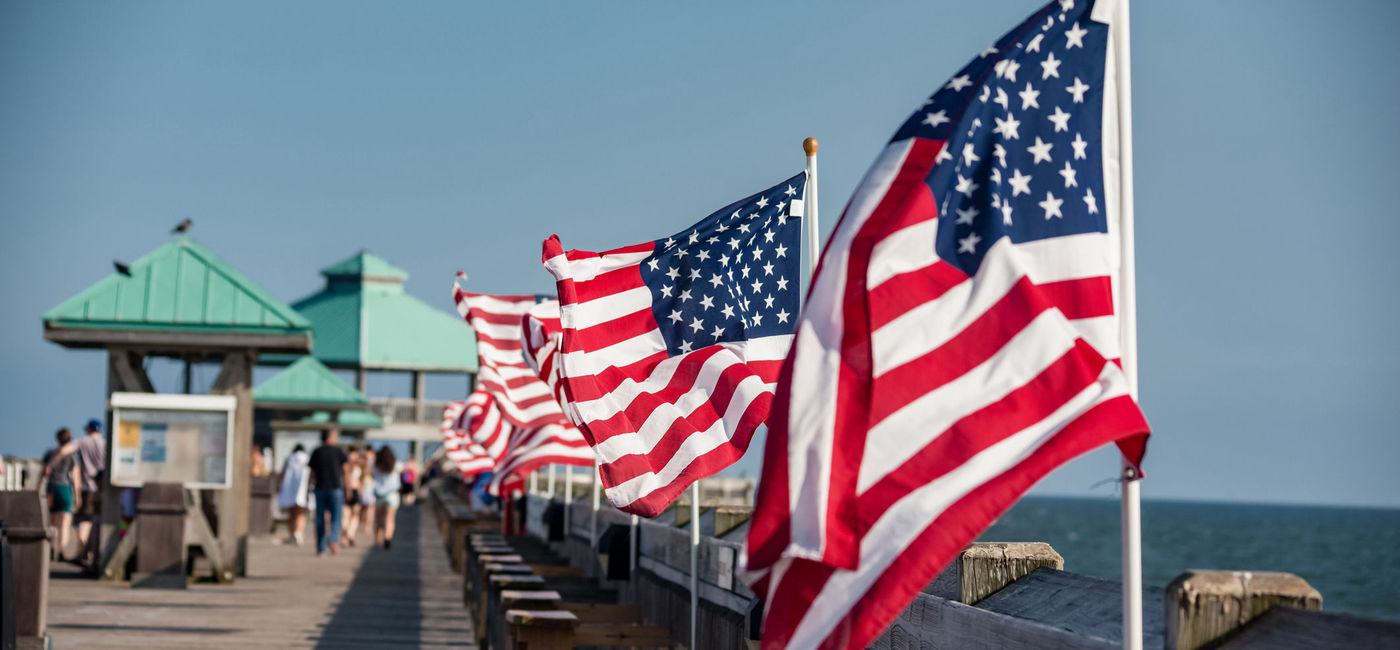 Image: American flags waving on a pier in Charleston, South Carolina. (photo via iStock/Getty Images Plus/eurobanks)