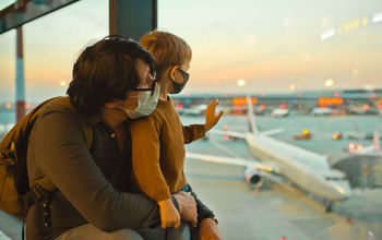 Family in protective face masks at airport.