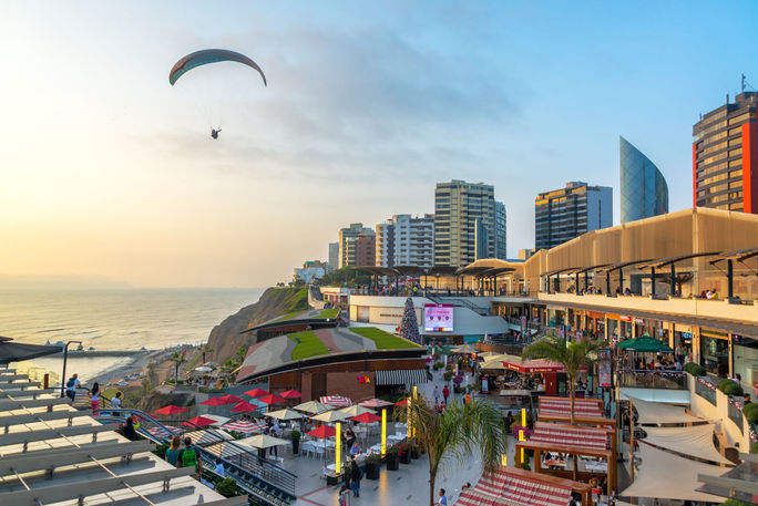 A paraglider flies over the Larcomar in Lima, Peru