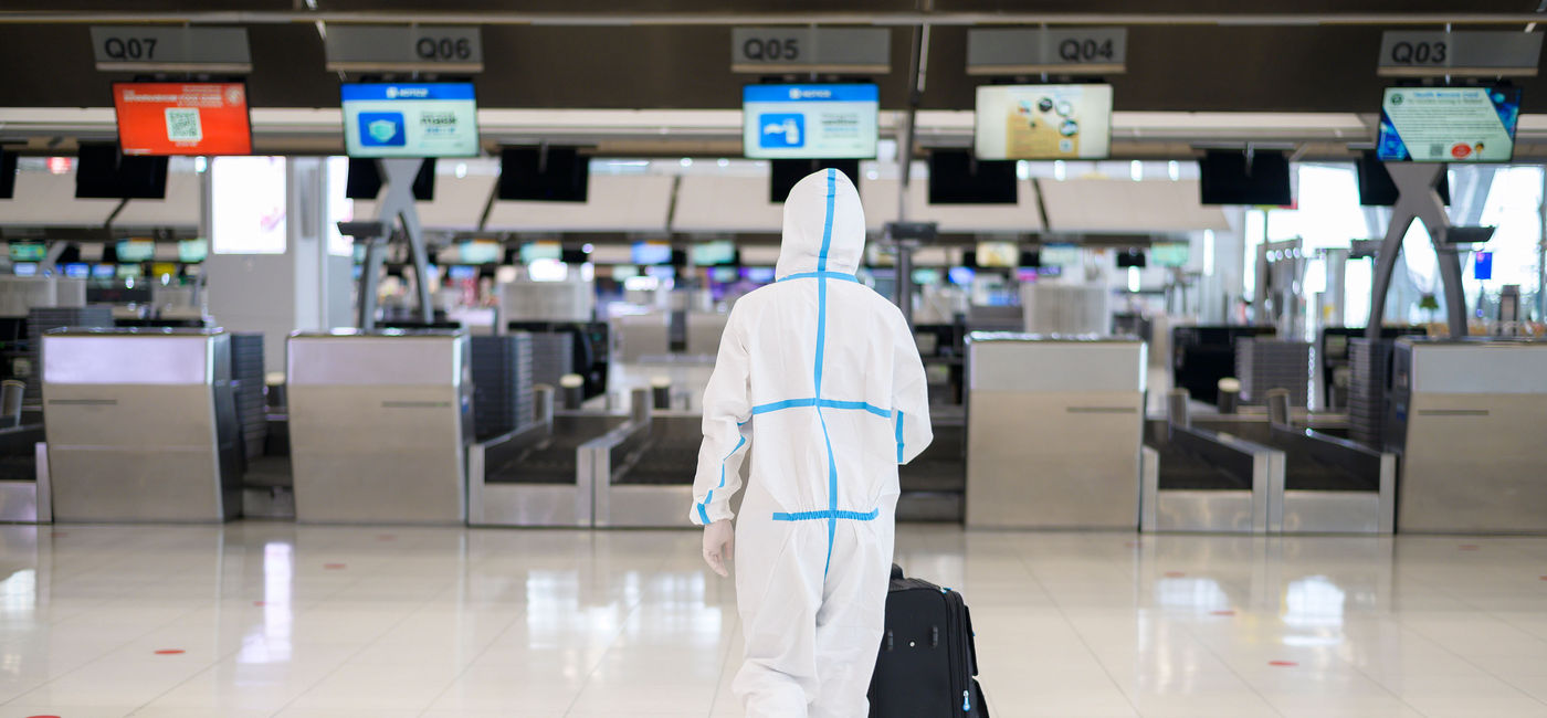 Image: Man wearing PPE suit at the airport (photo via tonefotografia / iStock / Getty Images Plus)
