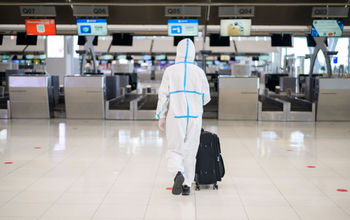 Man wearing PPE suit at the airport