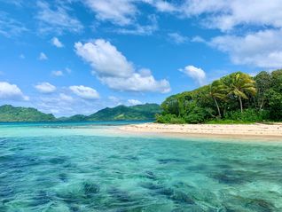 Island with turquoise water, white sand beach, blue sky