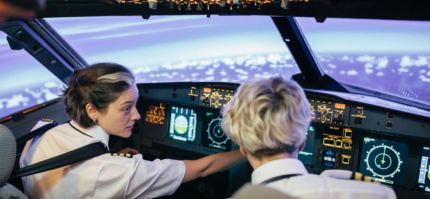 Image: Flight instructor and trainee in a simulator cockpit. (Photo via iStock/Getty Images E+/Thomas_EyeDesign)