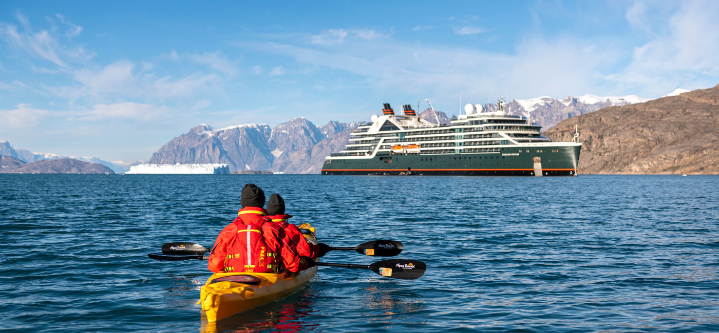 Image: Kayakers paddle back to the Seabourn Venture off the coast of Greenland while on an expedition itinerary. (Photo Credit: Seabourn)