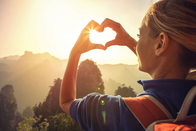 Traveler making a heart-shaped outline with her hands. traveler, young woman, heart, outdoors, nature, park