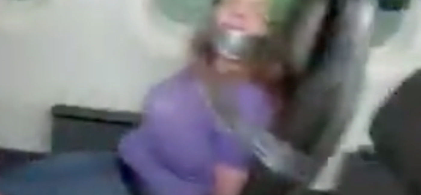 Image: A still from social media footage of an airplane passenger duct-taped to her seat after assaulting crew members. (photo via TikTok/@lol.airee)