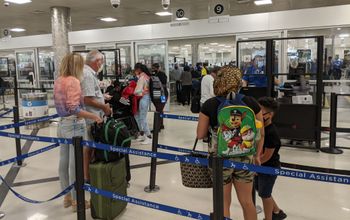 Travelers wait in the security line at the airport