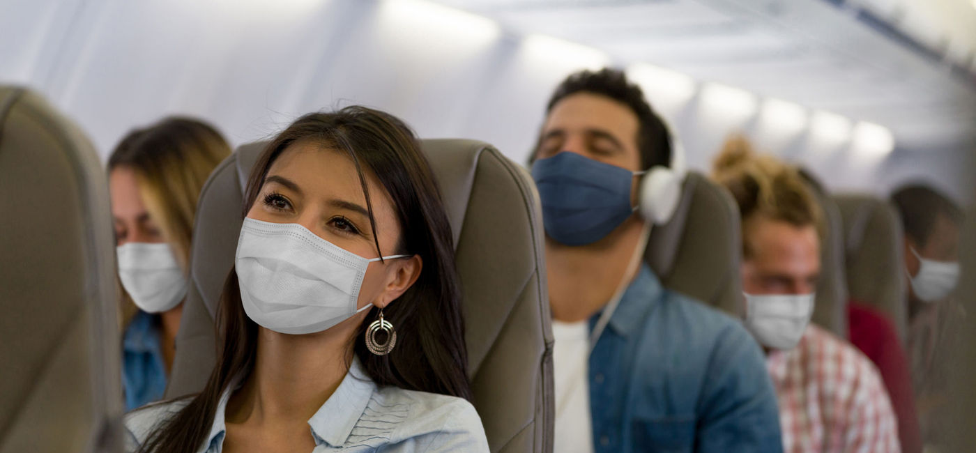 Image: People wearing masks on a plane. (Hispanolistic / Getty Images)