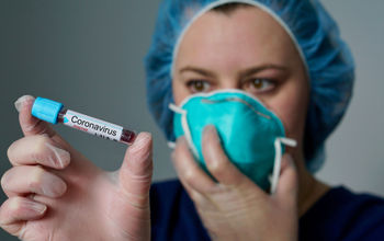 Nurse holding a coronavirus-positive test tube.