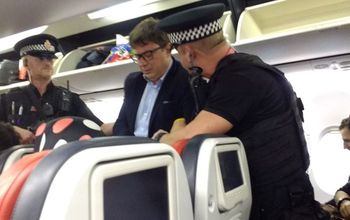 Guy Lardinois being arrested by police after striking a flight attendant. 