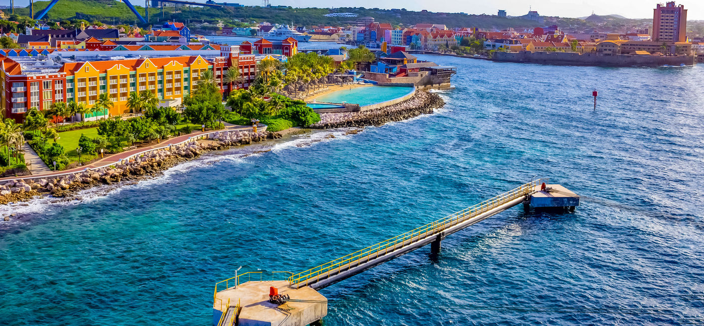 Image: A beautiful bay with colorful architecture in Curacao, one of the Lesser Antilles islands in the Caribbean Sea. (photo via iStock/Getty Images Plus/Marina113)