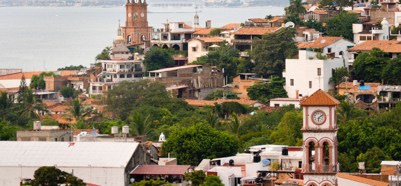 Image: PHOTO: Downtown Puerto Vallarta with cruise ship in the background. (Photo via iStock/Getty Images Plus/YinYang)