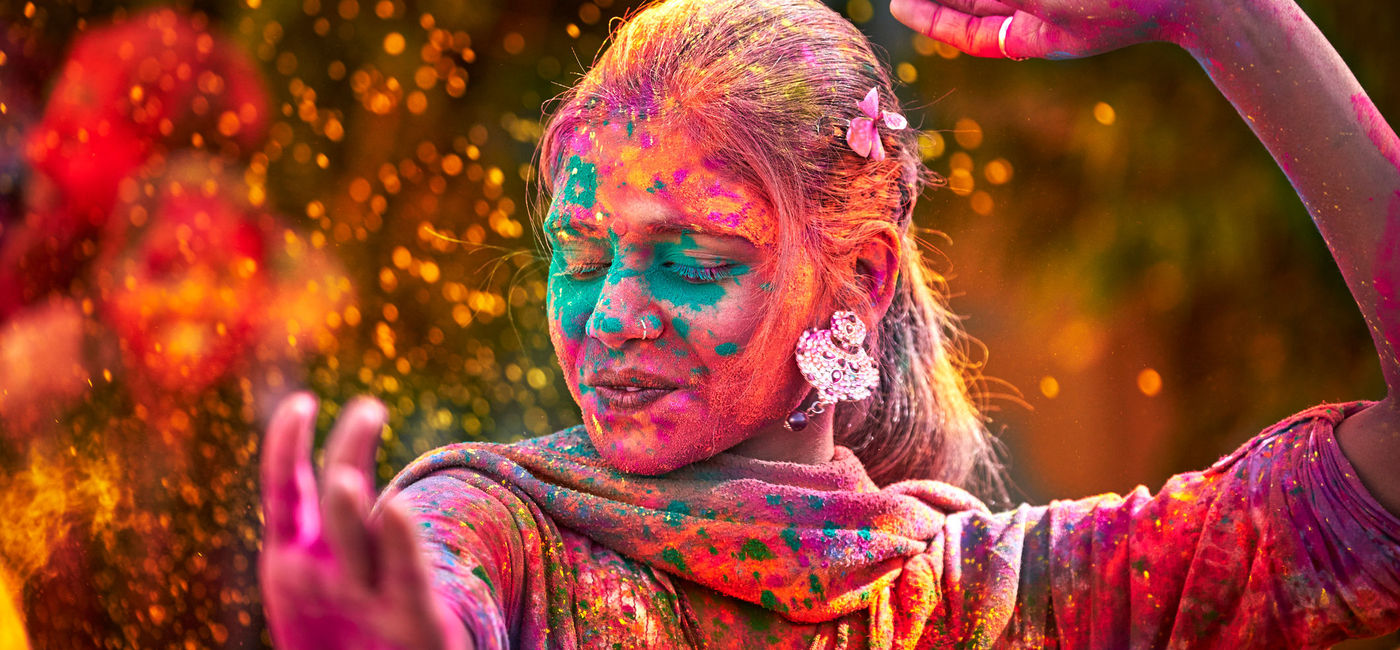Image: An Indian woman dancing during Holi. (photo via E+ / maodesign)