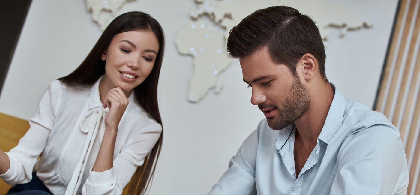 Image: PHOTO: Young man signing a contract for a trip with agent sitting at the travel agency office. (photo via Getty Images)