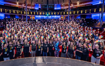 CoNexion attendees hold up their Nexion fans during a general session. 