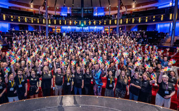 CoNexion attendees hold up their Nexion fans during a general session. 