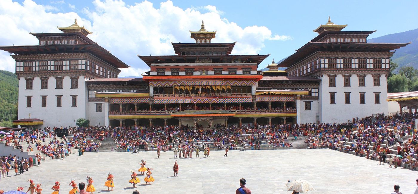 Image: People gather to receive blessings and watch masked dancers perform at the annual Thimphu festival in Bhutan. (photo via Tourism Council of Bhutan) ((photo via Tourism Council of Bhutan))