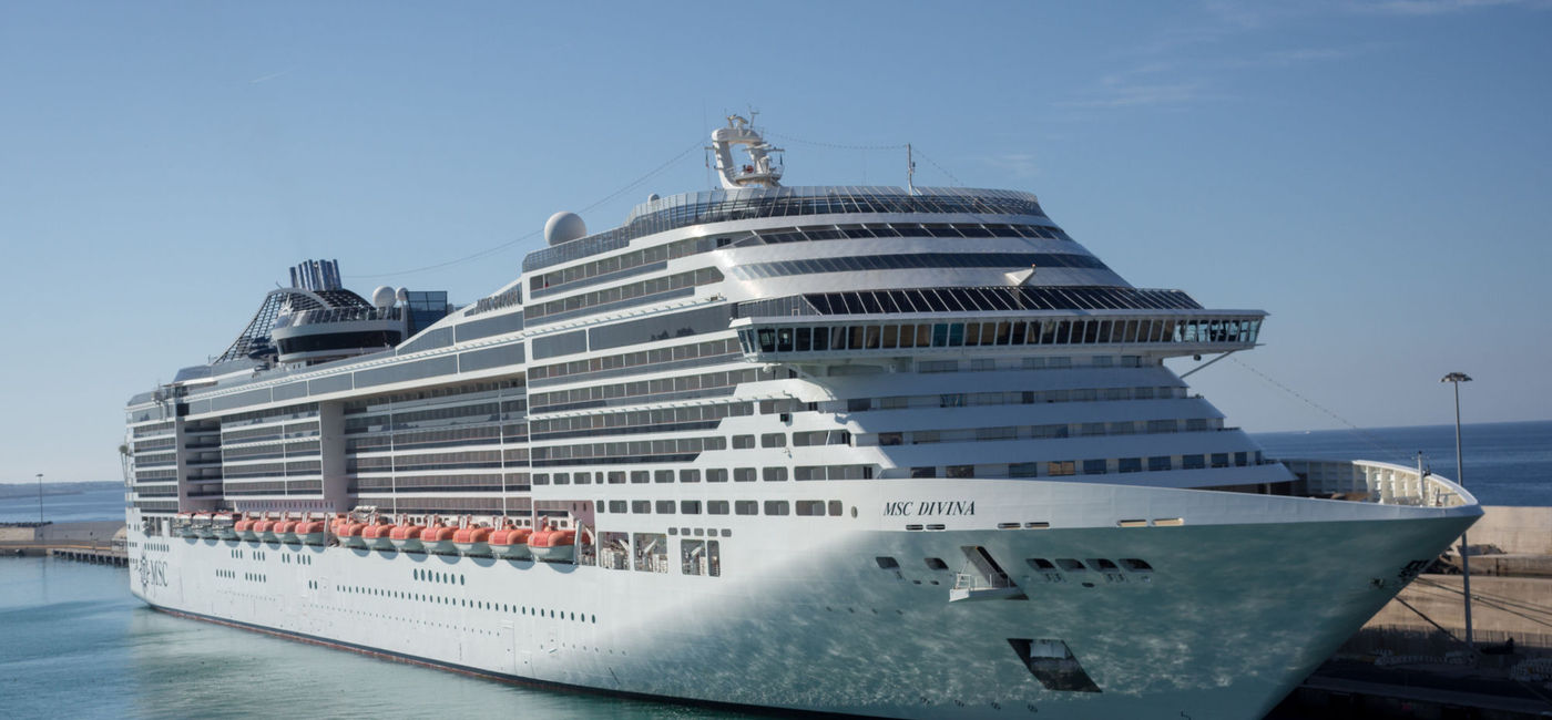 Image: PHOTO: MSC Divina cruise ship docked in Europe. (photo via Isaac74/iStock Editorial/Getty Images Plus)
