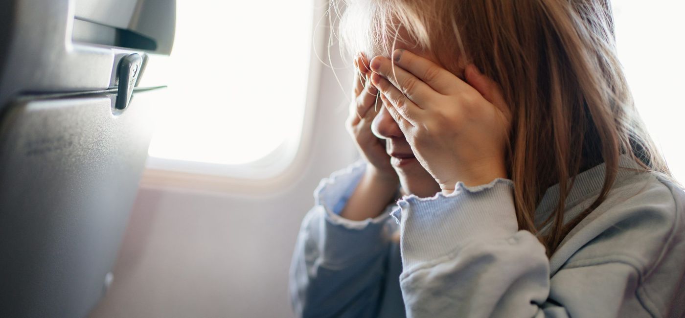 Image: A girl covers her eyes on an airplane. (photo via ALG Vacations) ((photo via ALG Vacations))