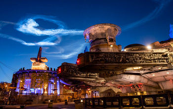 A vapor trail from SpaceX’s Falcon 9 rocket hangs in the air as seen from Star Wars: Galaxy’s Edge at Disney’s Hollywood Studios at Walt Disney World Resort