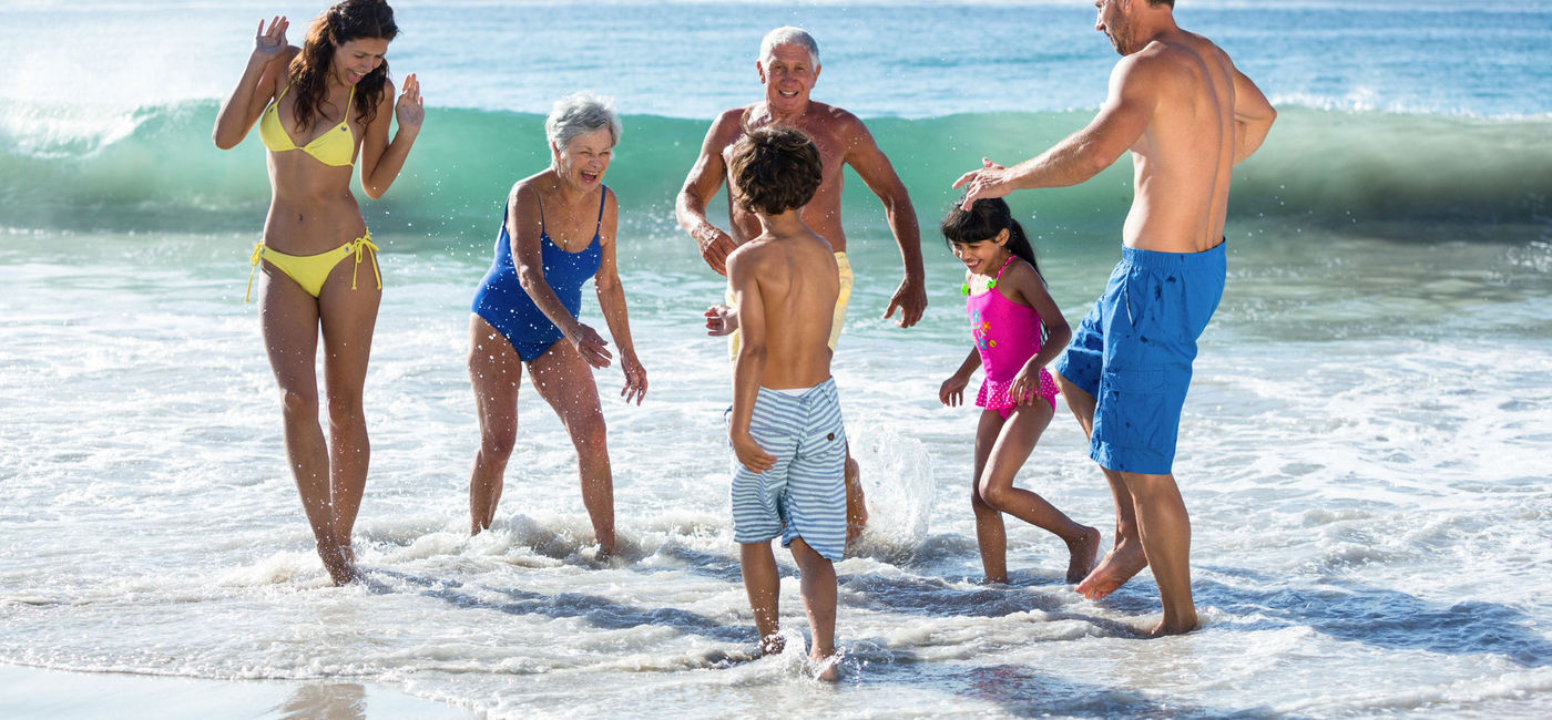Image: Multi-generational family group playing in the surf. (Photo via iStock / Getty Images Plus / Wavebreakmedia)