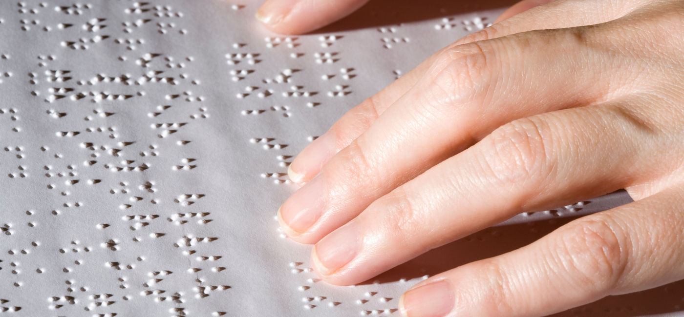 Image: Hands on Braille text. (Photo Credit: ericsphotography / E+)