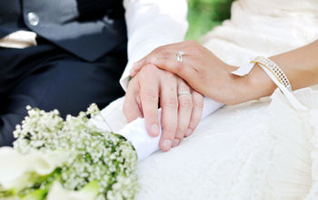 A husband and wife holding hands on their wedding day.