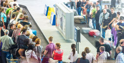 Lots of people getting luggage at airport.