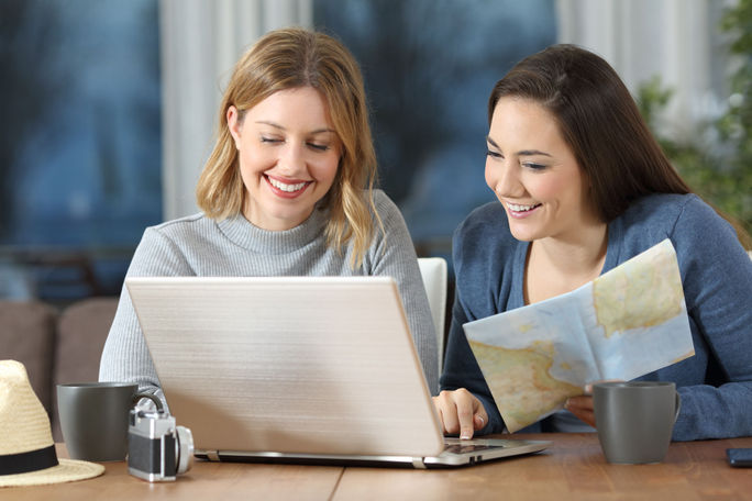Friends using laptop to search travel Friends using laptop to search travel