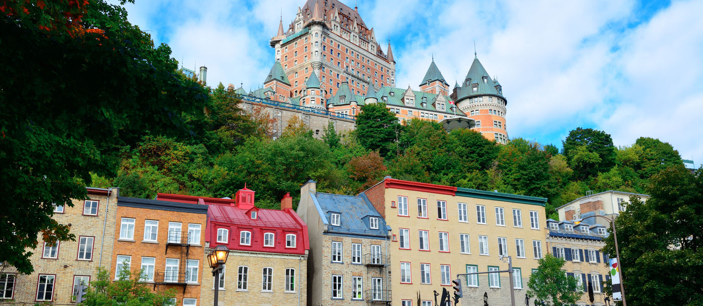 Chateau Frontenac in the day with colorful buildings on street in Quebec City (Photo via rabbit75_ist / iStock / Getty Images Plus)