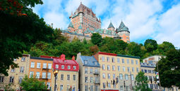 Chateau Frontenac in the day with colorful buildings on street in Quebec City (Photo via rabbit75_ist / iStock / Getty Images Plus)