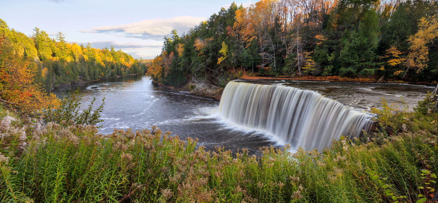 Image: A panoramic view of the very picturesque Tahquamenon Falls and Tahquamenon River during Autumn, Upper Peninsula, Michigan, USA (photo via DougLemke / iStock / Getty Images Plus)