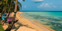 tropical beach with hammock on palm, relax concept from Nicaragua (Photo via riderfoot / iStock / Getty Images Plus)
