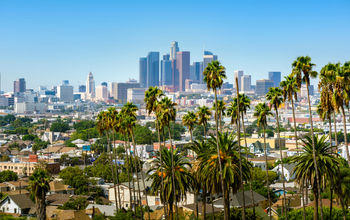 Los Angeles, California, USA downtown skyline and palm trees in foreground (choness / iStock / Getty Images Plus)