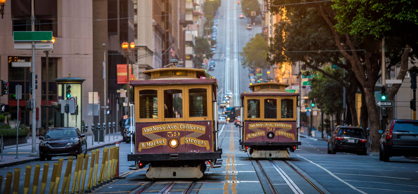 Image: Historic traditional cable cars riding through San Francisco, California. (photo via bluejayphoto / iStock / Getty Images Plus)