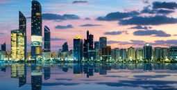 View of Abu Dhabi Skyline at sunset, United Arab Emirates (photo via vwalakte/iStock/Getty Images Plus)