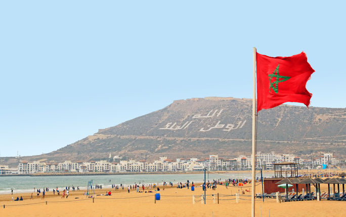 The beautiful beach in Agadir with flag of Morocco The beautiful beach in Agadir with flag of Morocco. (photo via evp82/iStock/Getty Images Plus)