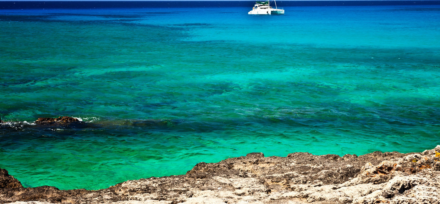 Image: Large catamaran sailing in Grand Cayman, Cayman Islands. (photo via fallbrook/iStock/Getty Images Plus)