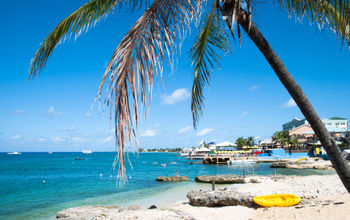 View of George Town coastline on Grand Cayman island (photo via virsuziglis/iStock/Getty Images Plus)