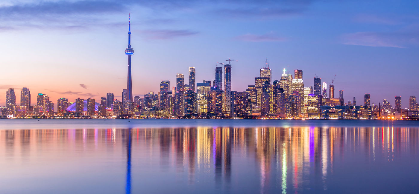 Image: The Toronto skyline at dusk. (Photo via diegograndi / iStock / Getty Images Plus)