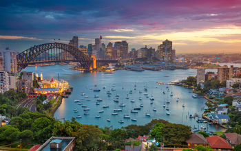 Cityscape image of Sydney, Australia with Harbour Bridge and Sydney skyline during sunset. (photo via RudyBalasko / iStock / Getty Images Plus)